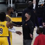 Los Angeles Lakers guard Wesley Matthews (9) holds back forward LeBron James (23) during a timeout in the third quarter of Game 6 of an NBA basketball first-round playoff series Thursday, June 3, 2021, in Los Angeles. (AP Photo/Ashley Landis)