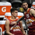 Denver Nuggets guard Austin Rivers, left, consoles forward Michael Porter Jr. as he takes a seat on the bench after being pulled from the floor late in the second half of Game 4 of an NBA second-round playoff series against the Phoenix Suns, Sunday, June 13, 2021, in Denver. Phoenix won 125-118 to sweep the series. (AP Photo/David Zalubowski)
