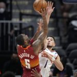 Phoenix Suns guard Devin Booker, back, contests a shot by Denver Nuggets forward Will Barton in the first half of Game 4 of an NBA second-round playoff series Sunday, June 13, 2021, in Denver. (AP Photo/David Zalubowski)