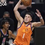 Phoenix Suns guard Devin Booker, right, dunks as Los Angeles Clippers guard Terance Mann watches during the first half in Game 6 of the NBA basketball Western Conference Finals Wednesday, June 30, 2021, in Los Angeles. (AP Photo/Mark J. Terrill)