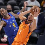 Phoenix Suns guard Devin Booker, right, pulls in a rebound as Denver Nuggets forward Will Barton defends during the first half of Game 3 of an NBA second-round playoff series Friday, June 11, 2021, in Denver. (AP Photo/David Zalubowski)