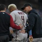 Arizona Diamondbacks' Ketel Marte, center, walks with manager Torey Lovullo, right, and a team official after an injury during the first inning with of a baseball game against the San Diego Padres, Saturday, June 26, 2021, in San Diego. (AP Photo/Gregory Bull)