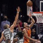 Phoenix Suns guard Devin Booker, right, shoots as Los Angeles Clippers forward Nicolas Batum, left, and guard Terance Mann defend during the second half in Game 4 of the NBA basketball Western Conference Finals Saturday, June 26, 2021, in Los Angeles. (AP Photo/Mark J. Terrill)