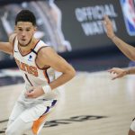Phoenix Suns guard Devin Booker, left, drives to the basket as Denver Nuggets guard Facundo Campazzo pursues in the first half of Game 4 of an NBA second-round playoff series Sunday, June 13, 2021, in Denver. (AP Photo/David Zalubowski)
