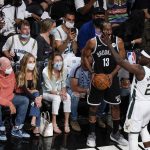 Fans watch as Milwaukee Bucks' Jrue Holiday (21) defends against Brooklyn Nets' James Harden (13) during the first half of Game 7 of a second-round NBA basketball playoff series Saturday, June 19, 2021, in New York. (AP Photo/Frank Franklin II)