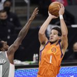 Phoenix Suns guard Devin Booker, right, shoots as Los Angeles Clippers guard Patrick Beverley defends during the first half in Game 4 of the NBA basketball Western Conference Finals Saturday, June 26, 2021, in Los Angeles. (AP Photo/Mark J. Terrill)