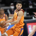 Phoenix Suns guard Devin Booker, front left, looks to pass the ball as Denver Nuggets center Nikola Jokic, right, defends in the first half of Game 3 of an NBA second-round playoff series Friday, June 11, 2021, in Denver. (AP Photo/David Zalubowski)