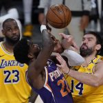 Phoenix Suns center Deandre Ayton (22) defends against Los Angeles Lakers center Marc Gasol (14) during the third quarter of Game 6 of an NBA basketball first-round playoff series Thursday, June 3, 2021, in Los Angeles. Los Angeles Lakers forward LeBron James (23) is at left. (AP Photo/Ashley Landis)