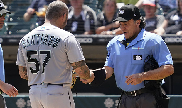 Home Plate umpire Phil Cuzzi, right, talks with Seattle Mariners relief pitcher Hector Santiago dur...