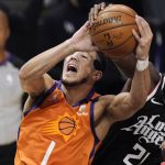 
              Phoenix Suns guard Devin Booker, left, is folded by Los Angeles Clippers guard Patrick Beverley as he tries to shoot during the first half in Game 3 of the NBA basketball Western Conference Finals Thursday, June 24, 2021, in Los Angeles. (AP Photo/Mark J. Terrill)
            