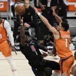 Los Angeles Clippers' Reggie Jackson, center left, is defended by Phoenix Suns' Devin Booker during the first half in Game 6 of the NBA basketball Western Conference Finals Wednesday, June 30, 2021, in Los Angeles. (AP Photo/Jae C. Hong)