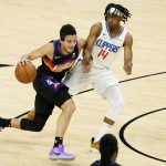 Phoenix Suns guard Devin Booker (1) drives as Los Angeles Clippers guard Terance Mann (14) defends during the first half of game 5 of the NBA basketball Western Conference Finals, Monday, June 28, 2021, in Phoenix. (AP Photo/Matt York)