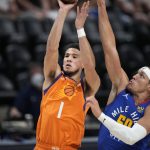 Phoenix Suns guard Devin Booker shoots as Denver Nuggets forward Aaron Gordon defends during the first half of Game 3 of an NBA second-round playoff series Friday, June 11, 2021, in Denver. (AP Photo/David Zalubowski)