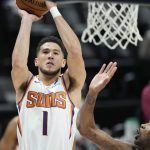 Phoenix Suns guard Devin Booker, left, goes up for a basket as Denver Nuggets forward Will Barton defends in the first half of Game 4 of an NBA second-round playoff series Sunday, June 13, 2021, in Denver. (AP Photo/David Zalubowski)