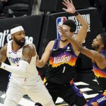 Los Angeles Clippers forward Marcus Morris Sr. looks to pass under pressure from Phoenix Suns guard Devin Booker (1) and forward Mikal Bridges, right, during the first half of game 5 of the NBA basketball Western Conference Finals, Monday, June 28, 2021, in Phoenix. (AP Photo/Matt York)