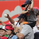 A young fan holds on while his dad reaches for an autograph before a baseball game between the Arizona Diamondbacks and the St. Louis Cardinals, Wednesday, June 30, 2021, in St. Louis. (AP Photo/Tom Gannam)