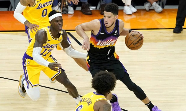 Phoenix Suns guard Devin Booker (1) drives as Los Angeles Lakers guard Dennis Schroder (17) defends...