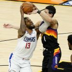 Los Angeles Clippers guard Paul George (13) drives as Phoenix Suns guard Devin Booker (1) defends during the second half of game 5 of the NBA basketball Western Conference Finals, Monday, June 28, 2021, in Phoenix. (AP Photo/Matt York)