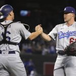 Los Angeles Dodgers' Will Smith, left, and Garrett Cleavinger (61) celebrate after the Dodgers defeated the Arizona Diamondbacks 9-3 in a baseball game Saturday, June 19, 2021, in Phoenix. (AP Photo/Rick Scuteri)