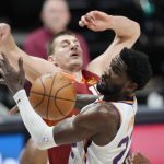 Phoenix Suns center Deandre Ayton, front, fights for control of a rebound with Denver Nuggets center Nikola Jokic in the first half of Game 4 of an NBA second-round playoff series Sunday, June 13, 2021, in Denver. (AP Photo/David Zalubowski)
