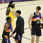 Phoenix Suns guard Devin Booker, center, greets teammates after Game 5 of an NBA basketball first-round playoff series as Los Angeles Lakers center Montrezl Harrell (15) walks off the court, Tuesday, June 1, 2021, in Phoenix. The Suns won 115-85. (AP Photo/Matt York)