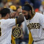 San Diego Padres' Fernando Tatis Jr., right, gets the "Swagg Chain" from teammate Tommy Pham (28) after hitting a home run during the first inning of a baseball game against the Arizona Diamondbacks, Friday, June 25, 2021, in San Diego. (AP Photo/Gregory Bull)