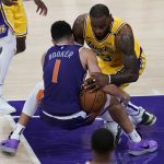 Phoenix Suns guard Devin Booker (1) and Los Angeles Lakers forward LeBron James (23) fight for the ball during the fourth quarter of Game 6 of an NBA basketball first-round playoff series Thursday, June 3, 2021, in Los Angeles. (AP Photo/Ashley Landis)