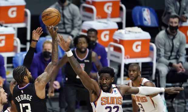 Los Angeles Clippers guard Paul George (13) shoots over Phoenix Suns center Deandre Ayton (22) duri...