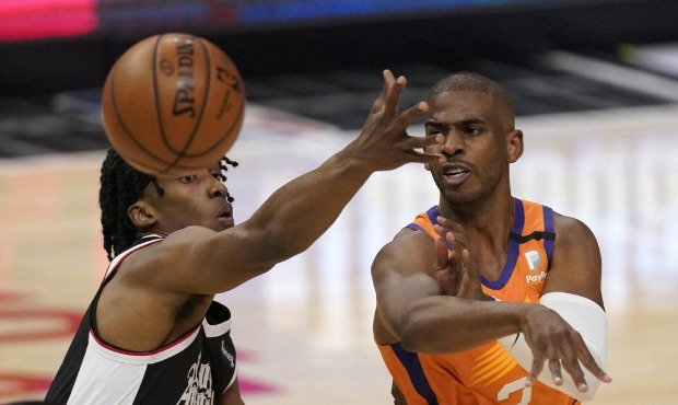 Phoenix Suns guard Chris Paul, right, passes while under pressure from Los Angeles Clippers guard T...