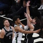 Milwaukee Bucks' Giannis Antetokounmpo, center, passes the ball away from Brooklyn Nets' Blake Griffin (2) and Joe Harris during the first half of Game 7 of a second-round NBA basketball playoff series Saturday, June 19, 2021, in New York. (AP Photo/Frank Franklin II)