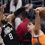 Los Angeles Clippers forward Marcus Morris Sr., right, and Phoenix Suns forward Dario Saric go after a rebound during the first half in Game 3 of the NBA basketball Western Conference Finals Thursday, June 24, 2021, in Los Angeles. (AP Photo/Mark J. Terrill)