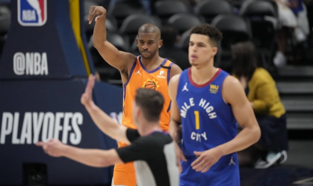 Phoenix Suns guard Chris Paul, back, reacts after hitting a basket, next to Denver Nuggets forward ...