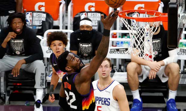 Deandre Ayton #22 of the Phoenix Suns drives to the basket against Reggie Jackson #1 of the Los Ang...