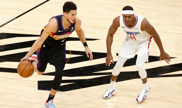Devin Booker #1 of the Phoenix Suns handles the ball against Rajon Rondo #4 of the LA Clippers duri...