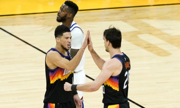 Phoenix Suns guard Devin Booker, left, high fives forward Dario Saric after a three pointer against...