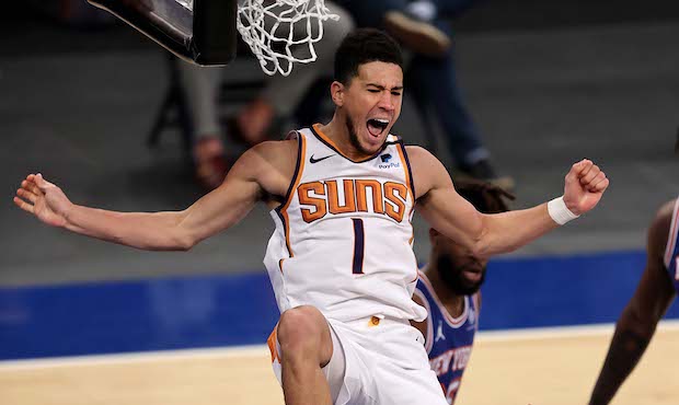 Devin Booker #1 of the Phoenix Suns celebrates his dunk in the third quarter against the New York K...