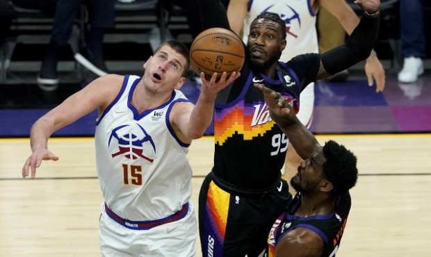 Denver Nuggets center Nikola Jokic (15) shoots as Phoenix Suns forward Jae Crowder (99) defends dur...