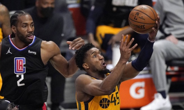 Utah Jazz guard Donovan Mitchell, right, shoots as Los Angeles Clippers forward Kawhi Leonard defen...
