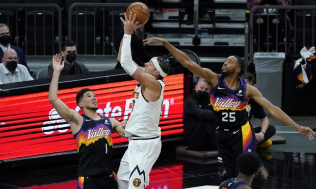 Denver Nuggets forward Aaron Gordon shoots as Phoenix Suns forward Mikal Bridges (25) and guard Dev...