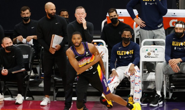 Mikal Bridges #25 of the Phoenix Suns reacts to a three-point shot against the Denver Nuggets durin...