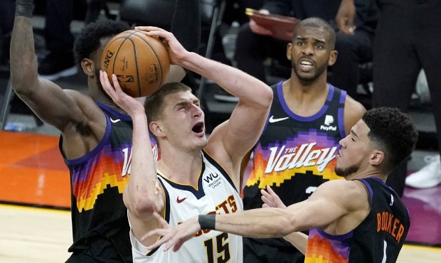 Denver Nuggets center Nikola Jokic (15) shoots over Phoenix Suns guard Devin Booker (1) during Game...