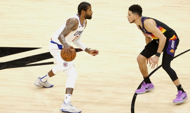 Paul George #13 of the LA Clippers controls the ball ahead of Devin Booker #1 of the Phoenix Suns d...
