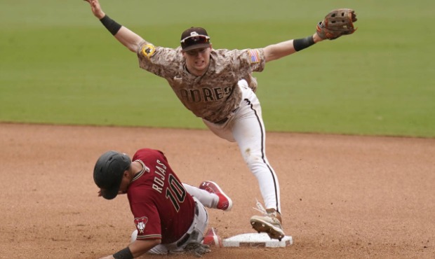 San Diego Padres second baseman Jake Cronenworth, top, leaps over Arizona Diamondbacks' Josh Rojas ...