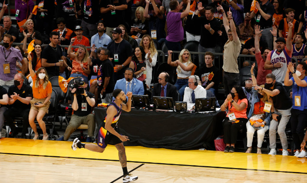Fans cheer after a Cameron Payne #15 of the Phoenix Suns three point basket against the Milwaukee B...