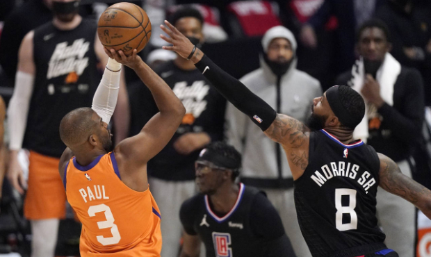 Phoenix Suns guard Chris Paul, left, shoots as Los Angeles Clippers forward Marcus Morris Sr. defen...
