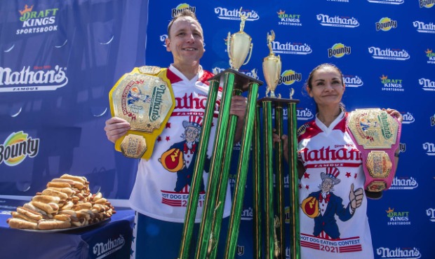 Winners Joey Chestnut and Michelle Lesco pose with their championship belts and trophies at the Nat...