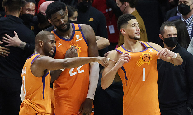 Devin Booker #1 of the Phoenix Suns celebrates with teammates Deandre Ayton #22 and Chris Paul #3  ...