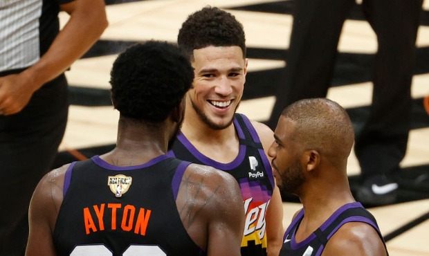 Devin Booker #1, Deandre Ayton #22 and Chris Paul #3 of the Phoenix Suns celebrate a win against th...