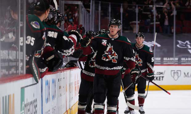 Jakob Chychrun #6 of the Arizona Coyotes celebrates with teammates on the bench after scoring a goa...