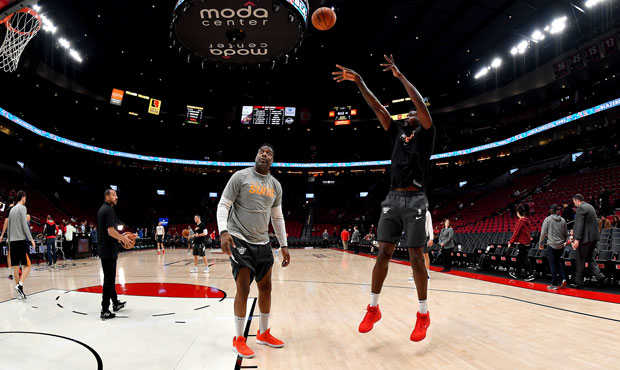 Deandre Ayton #22 of the Phoenix Suns (R) warms up with assistant coach Mark Bryant before the game...
